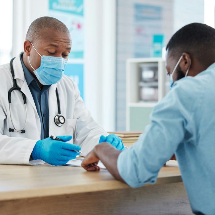 African american doctor talking to a patient in a consult. Doctor and patient talking about their c